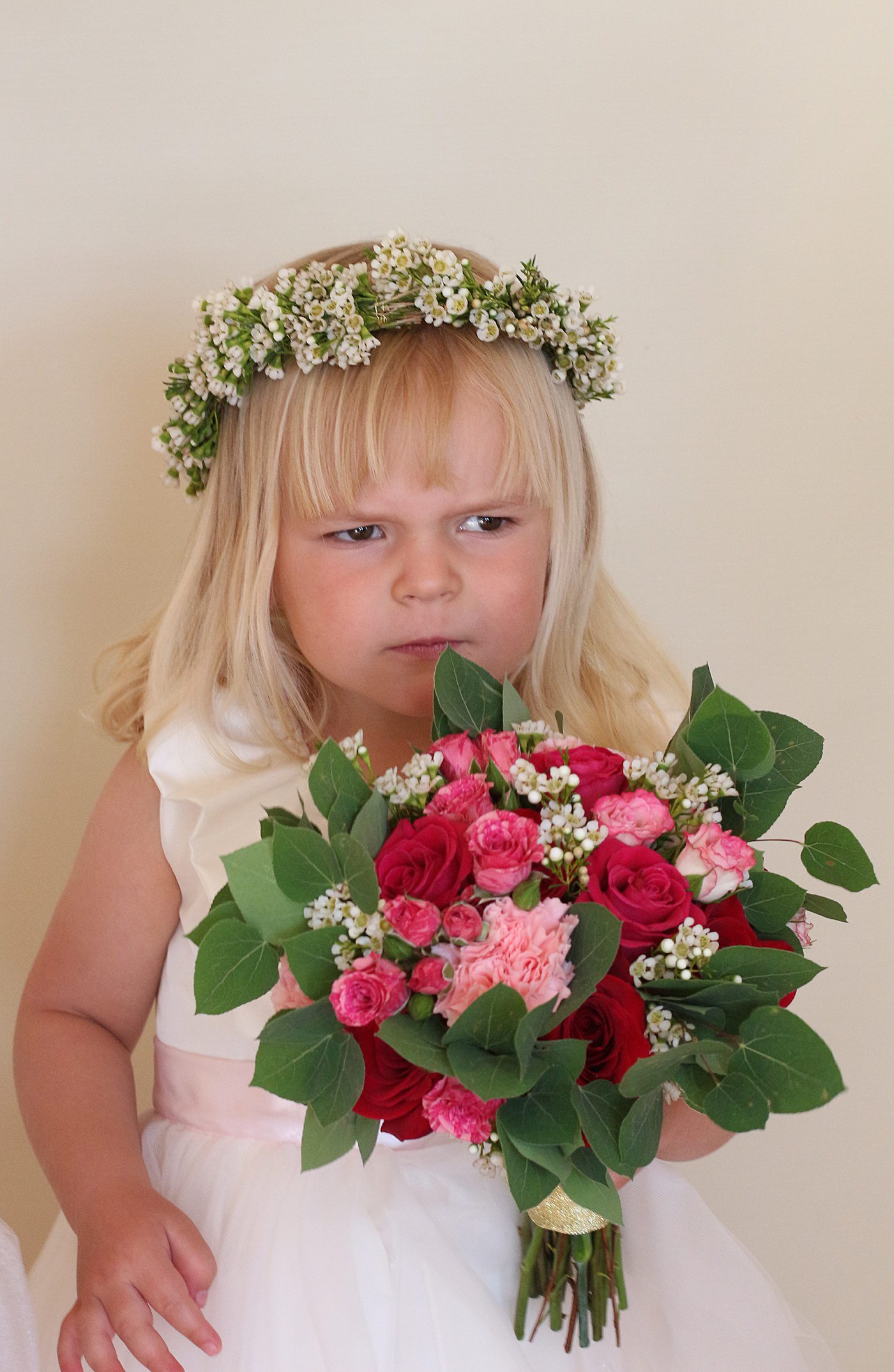 a flower girl holding a small bouquet