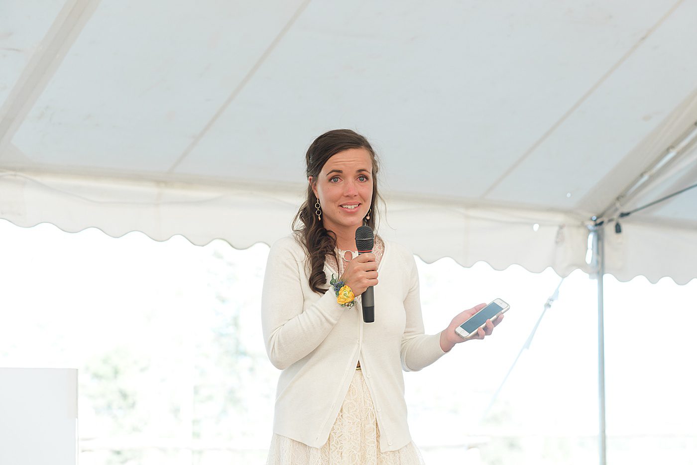 sister giving a wedding speech wearing a floral corsage