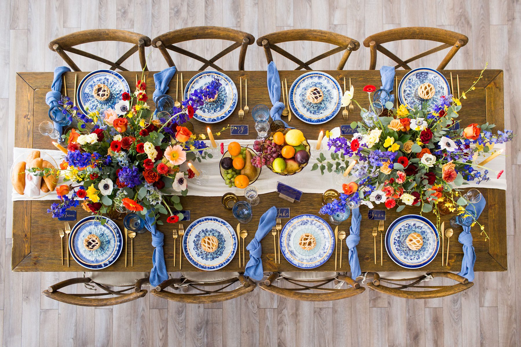 long dinner table with fancy place settings and colorful flowers