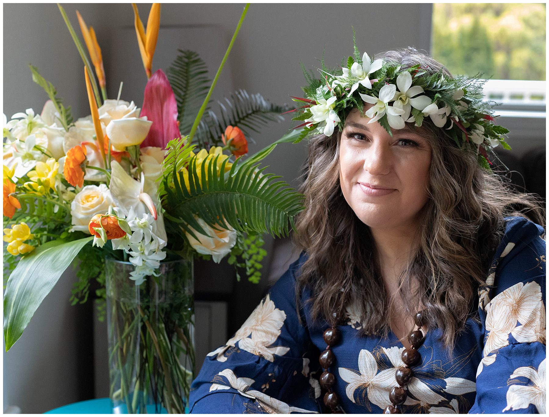 Rebecca Grant sitting next to a tropical floral arrangement