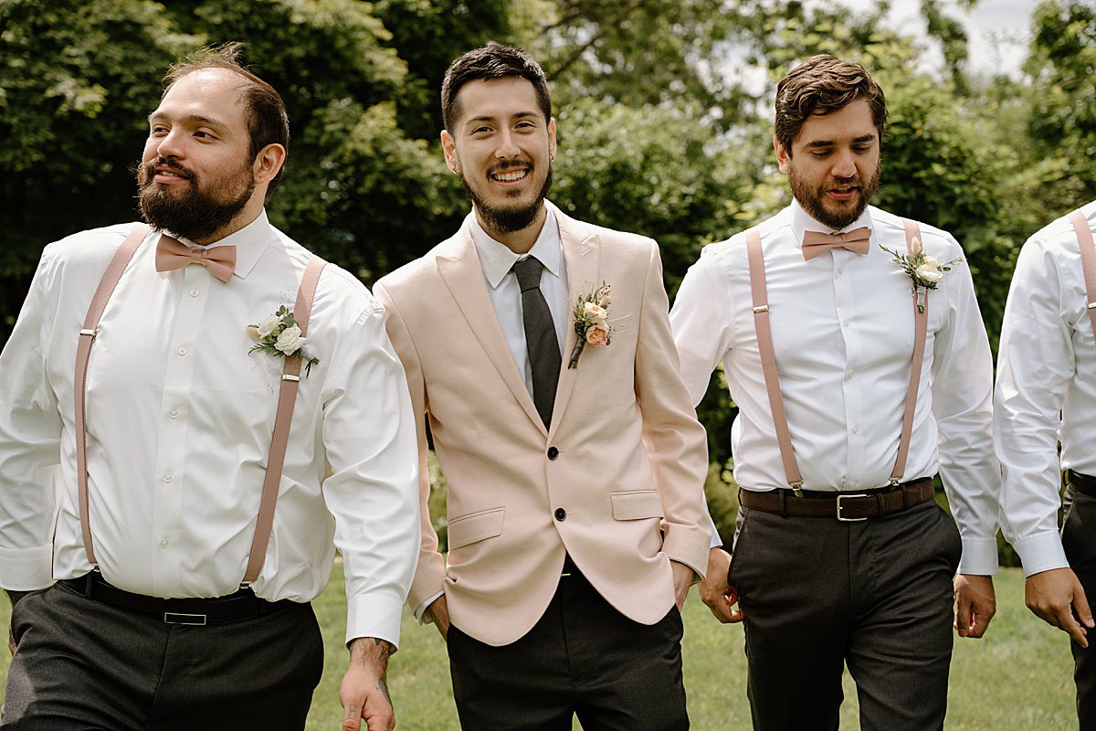 groom in light pink jacket with groomsmen