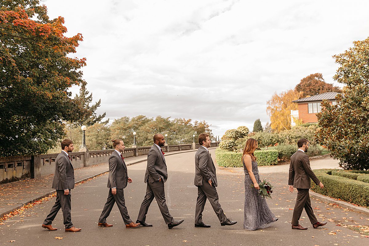 groomsmen and a groomslady walking across the street