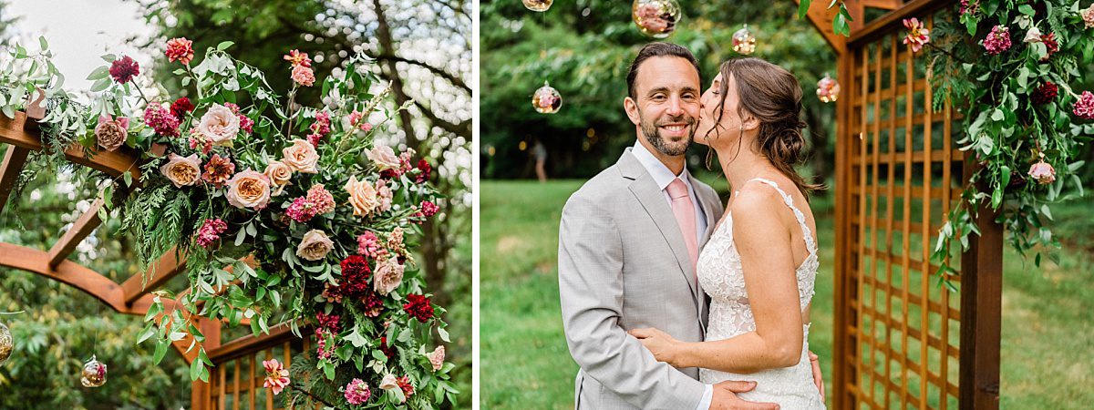 a bride kisses a groom next to lush dusty pink and green florals