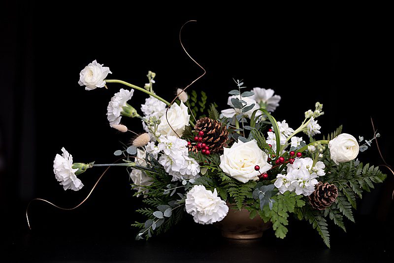 holiday floral centerpiece with pine cones and berries
