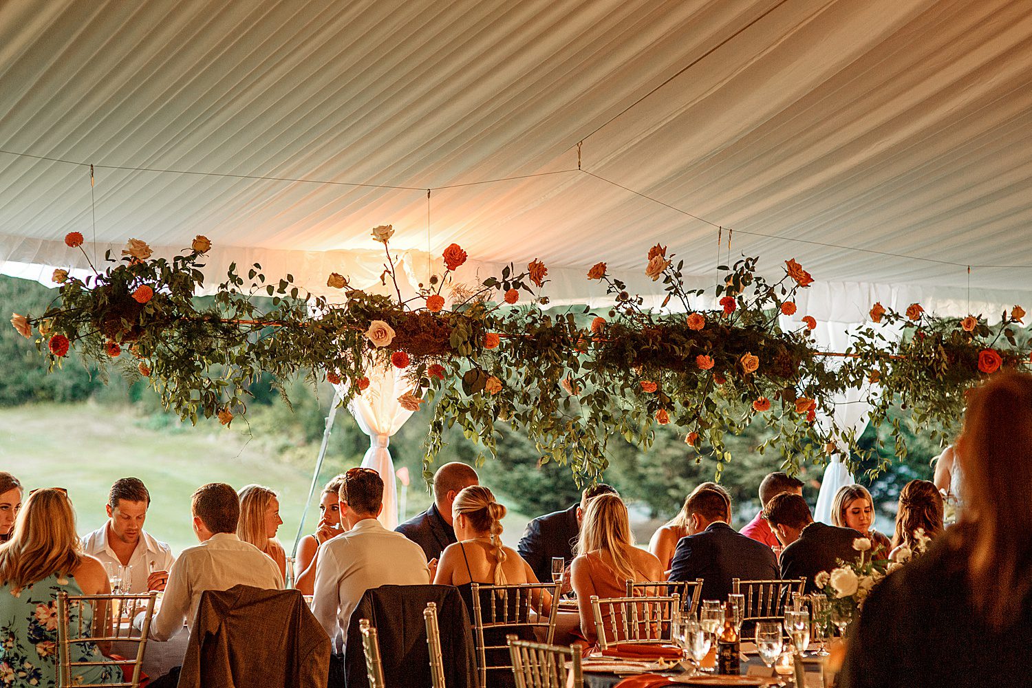 guests eating under suspended dahlias and roses