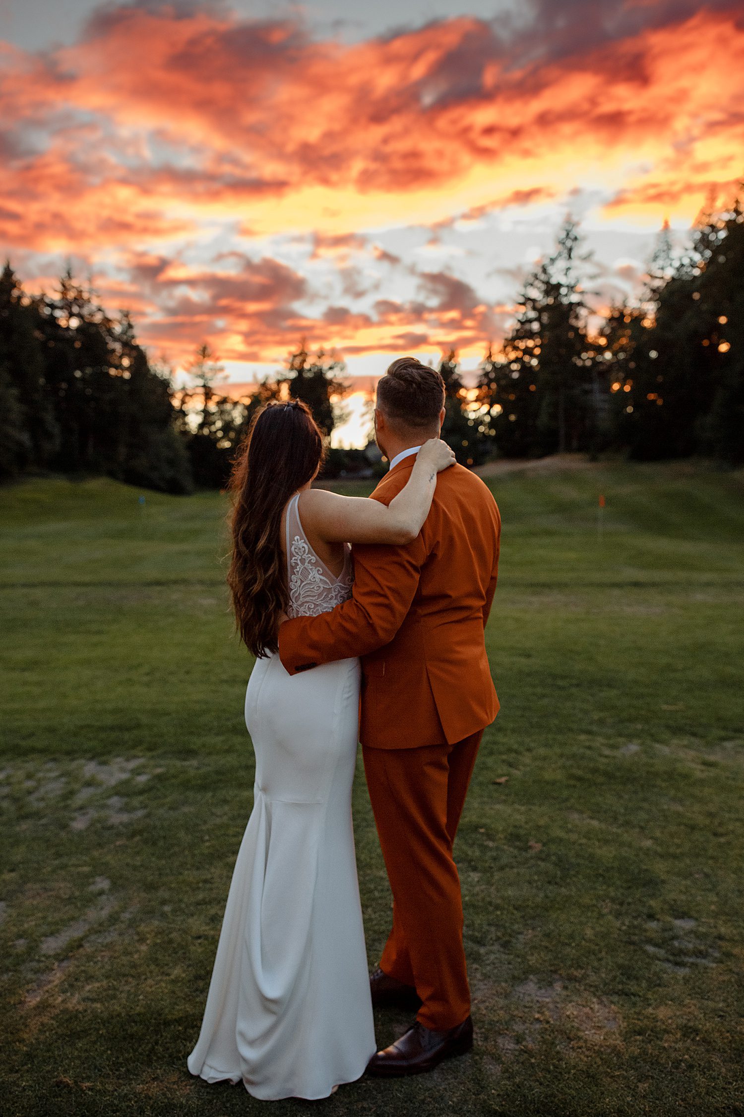 bride and groom look at sunset