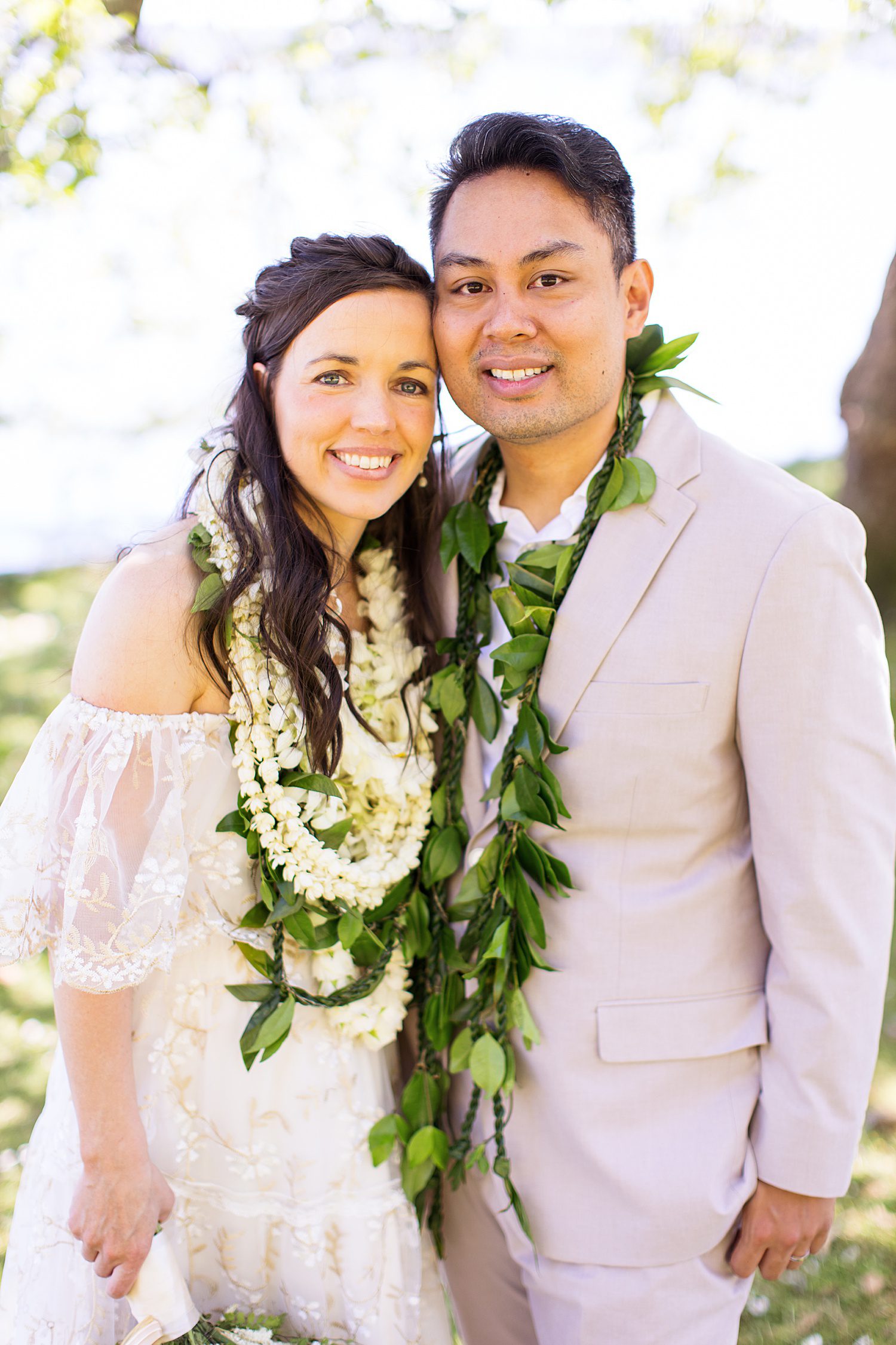 a bride and groom wearing Hawaiian wedding flowers