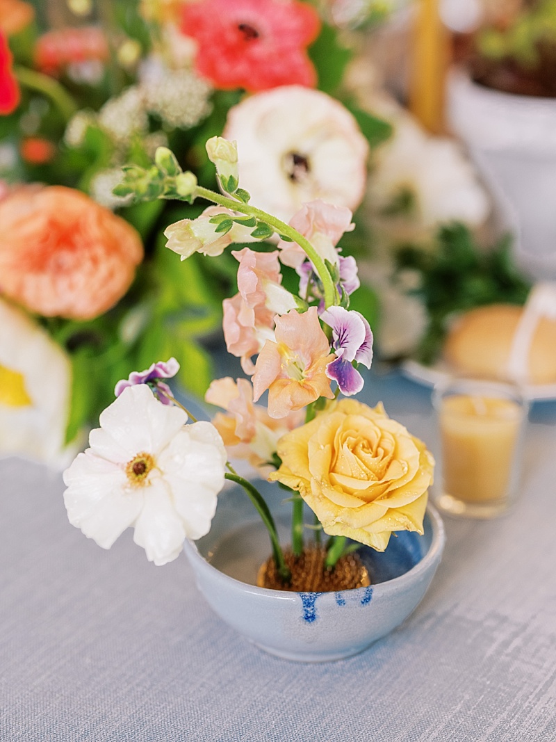 a flower frog supports colorful flowers in a vase