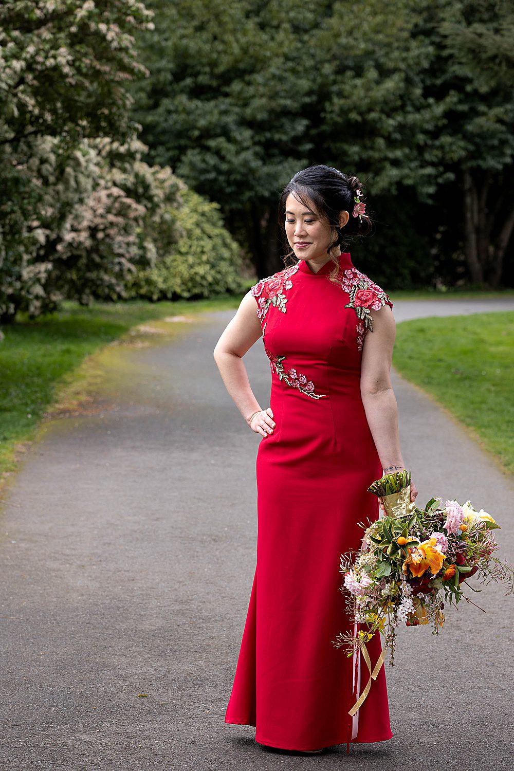 Chinese bride in red dress holding a colorful bouquet