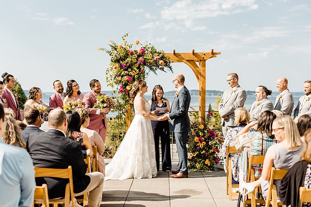 wedding ceremony with colorful arch florals