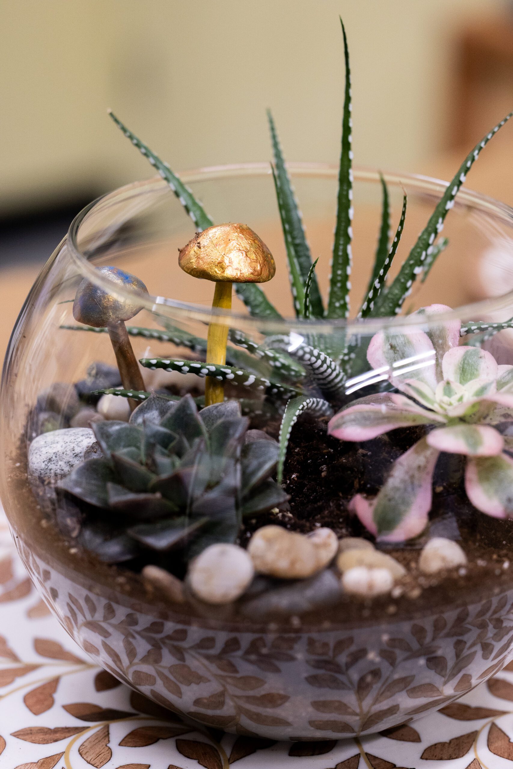 succulents in a glass bowl with ceramic mushrooms