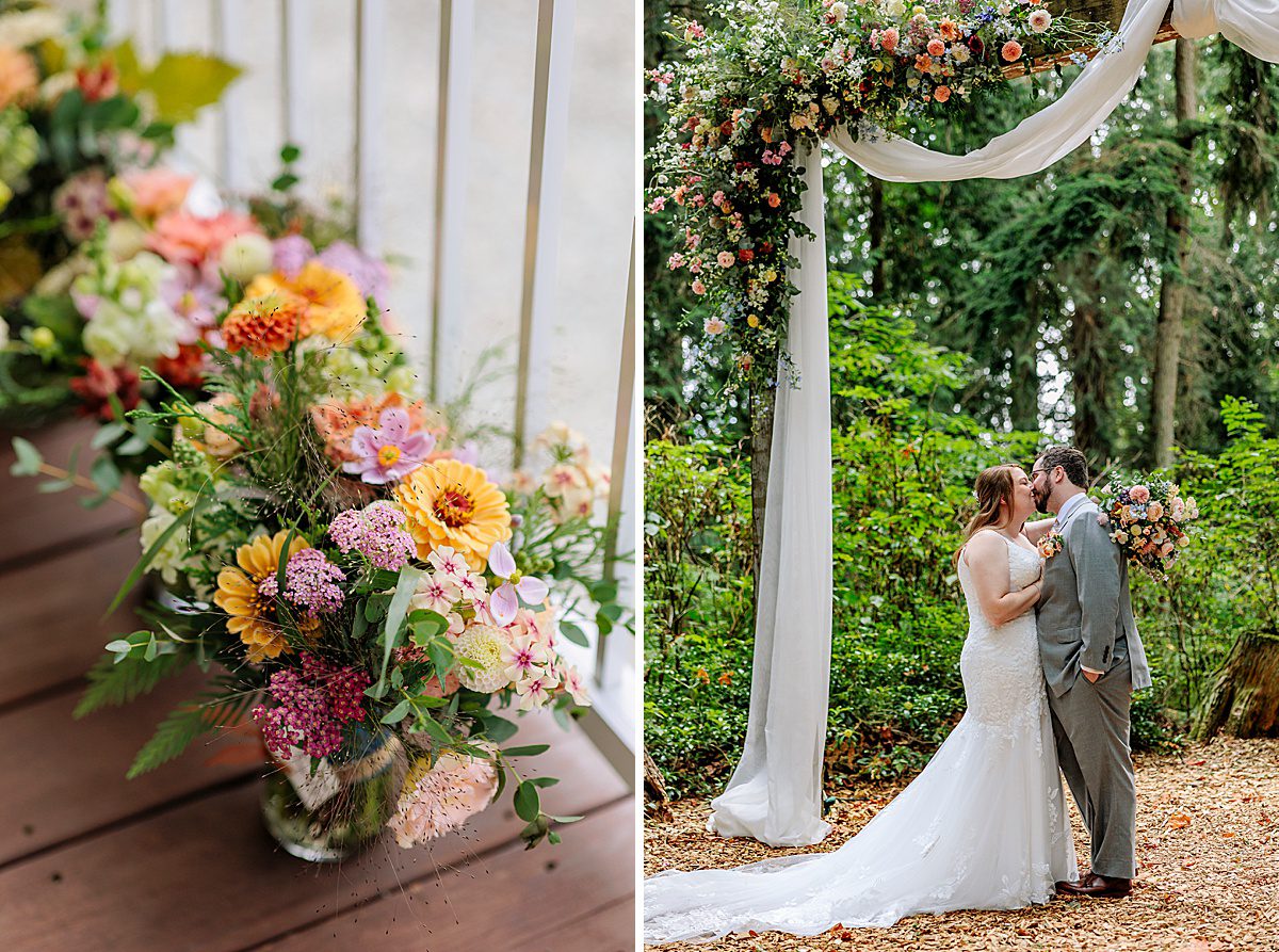 a bride and groom kiss under a floral heavy arch and white fabric